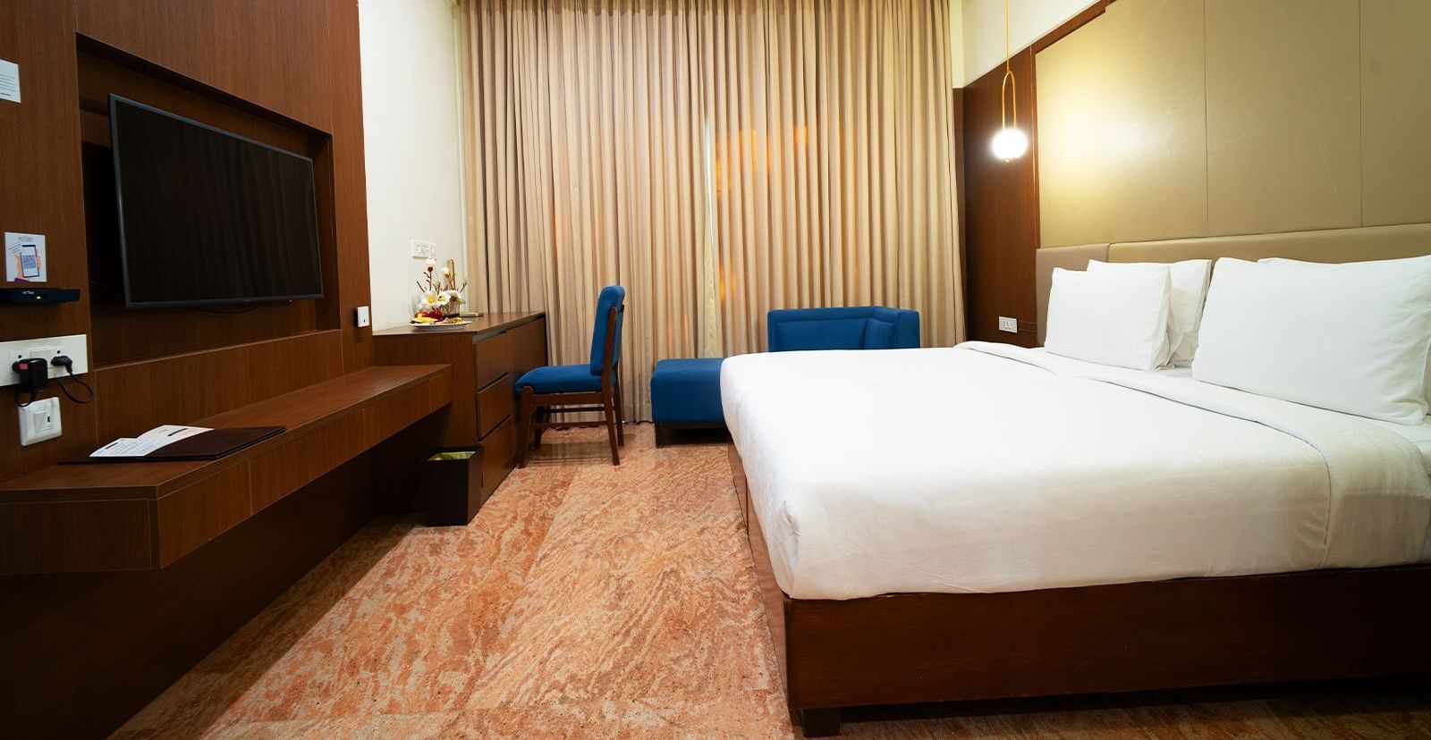 A close up shot of the twin beds in our hotel room placed in front of a wall-mounted television - Accord Chrome Airport Hotel